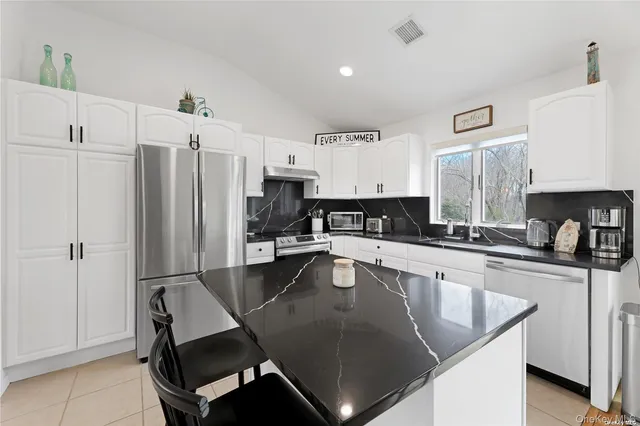 a kitchen with stainless steel appliances granite countertop a sink refrigerator and microwave