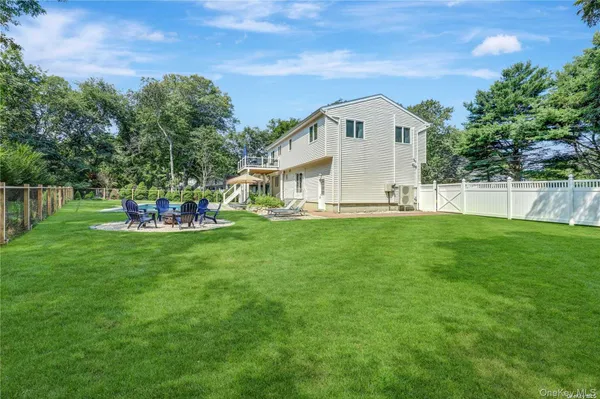 a view of a house with a big yard and large trees