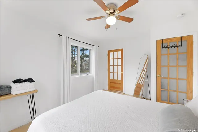 a bedroom with a bed and a large window