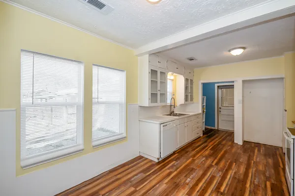 a large kitchen with kitchen island wooden floors and stainless steel appliances