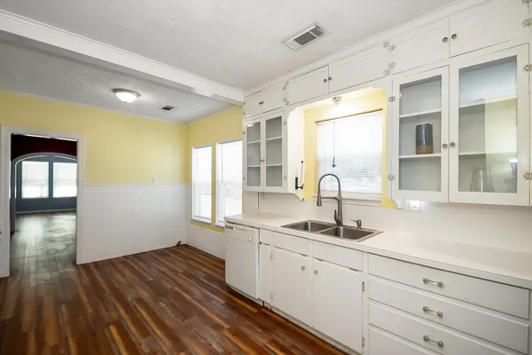 a kitchen with a sink and wooden floor