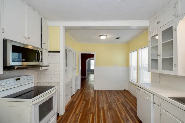 a kitchen with white cabinets and appliances