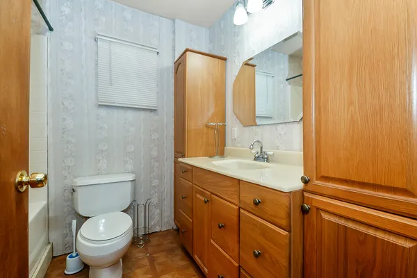 a bathroom with a granite countertop toilet sink and mirror
