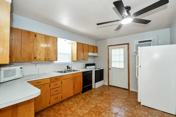 a kitchen with stainless steel appliances granite countertop a sink a stove and a refrigerator