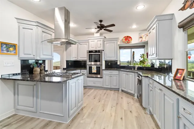 a kitchen with stainless steel appliances kitchen island granite countertop a stove a sink dishwasher and a microwave
