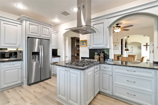 a kitchen with granite countertop a stove oven and refrigerator