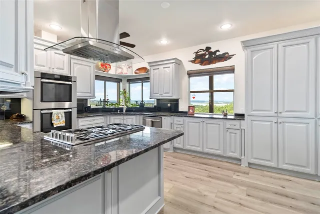 a kitchen with granite countertop a stove a sink and a microwave