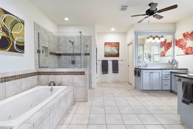 a bathroom with a tub a sink a mirror and a shower