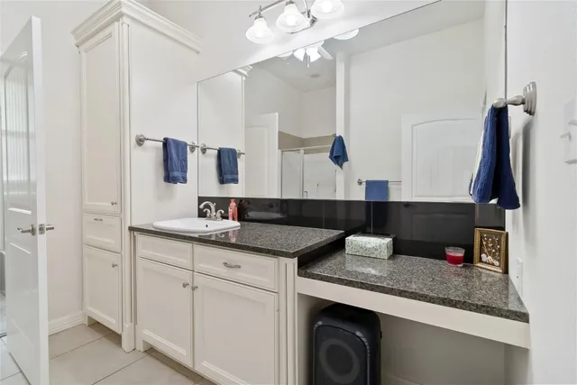 a bathroom with a granite countertop sink a mirror and vanity