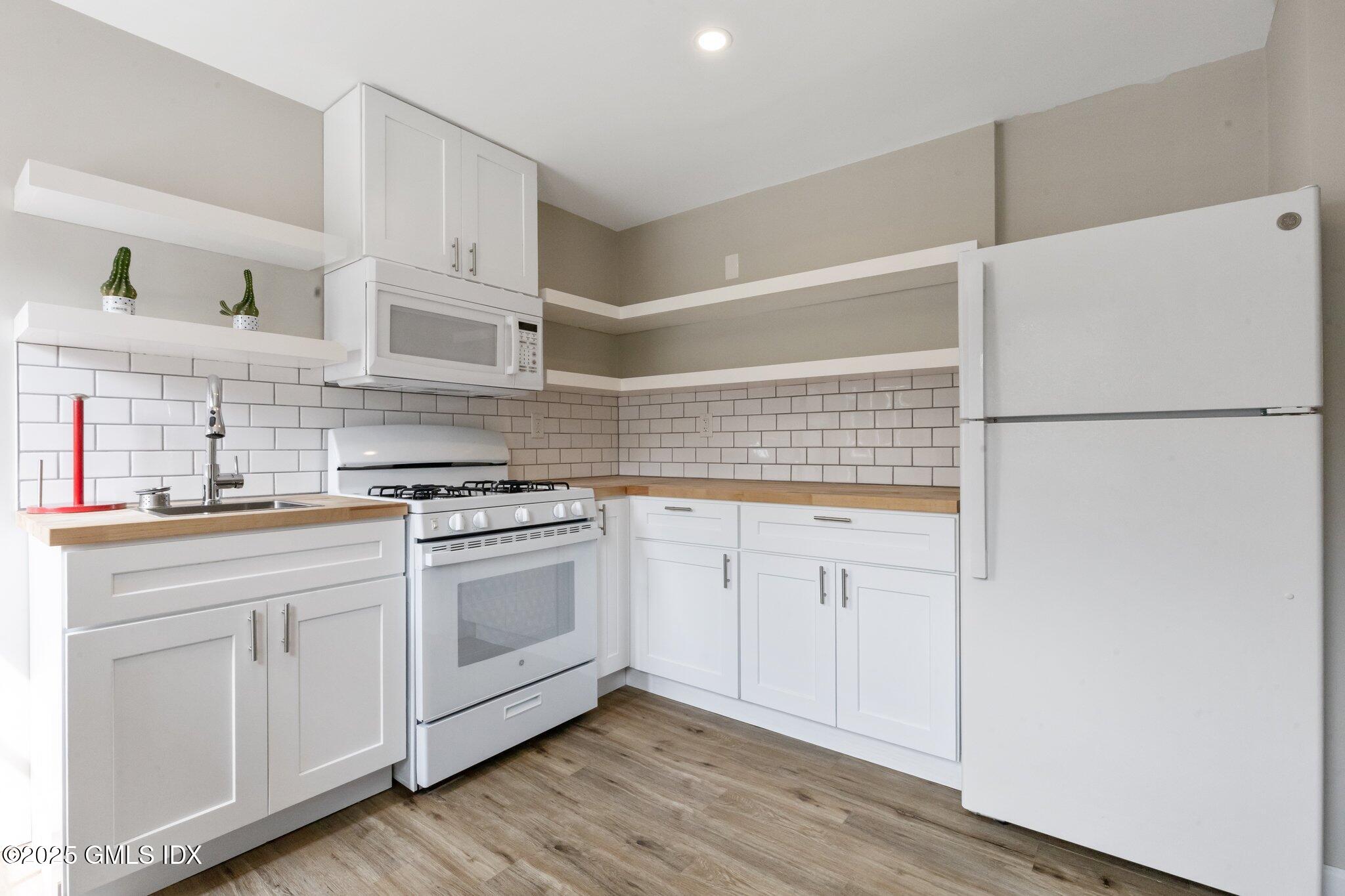 79 Hamilton Avenue, Unit B Greenwich, CT 06830 - Photo 11 of 18 a kitchen with white cabinets and white appliances