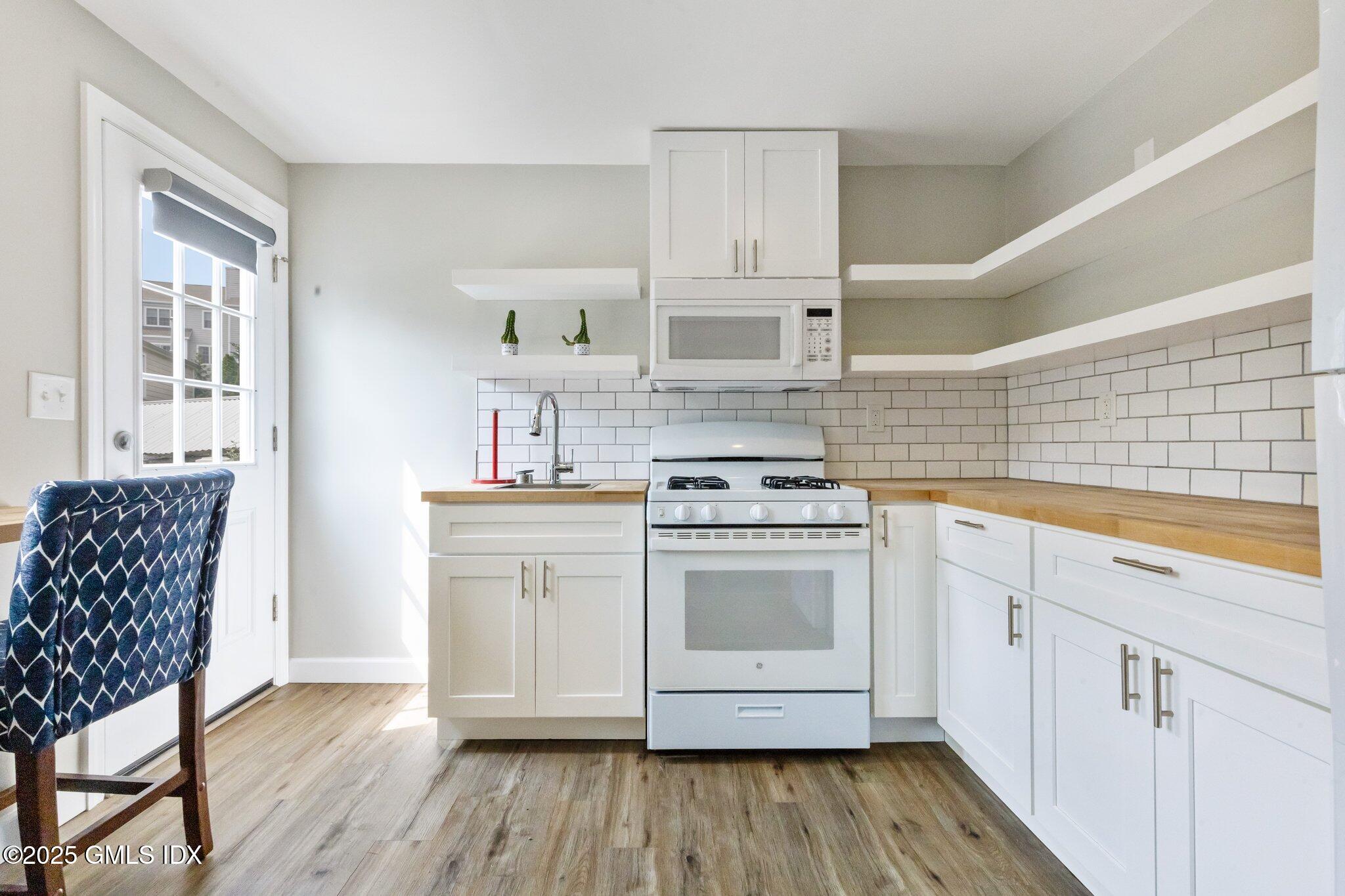 79 Hamilton Avenue, Unit B Greenwich, CT 06830 - Photo 15 of 18 a kitchen with cabinets and wooden floor