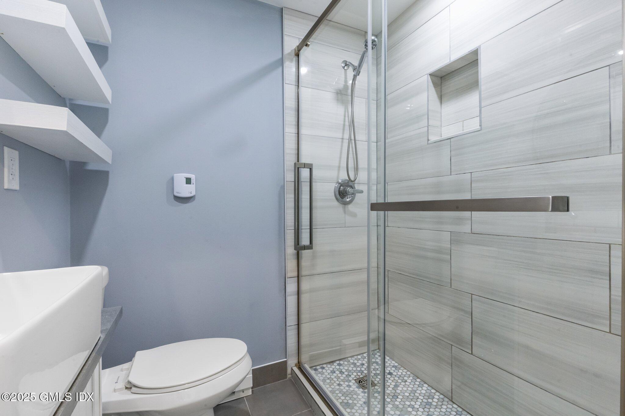 79 Hamilton Avenue, Unit B Greenwich, CT 06830 - Photo 3 of 18 a white toilet sitting next to a bathroom sink