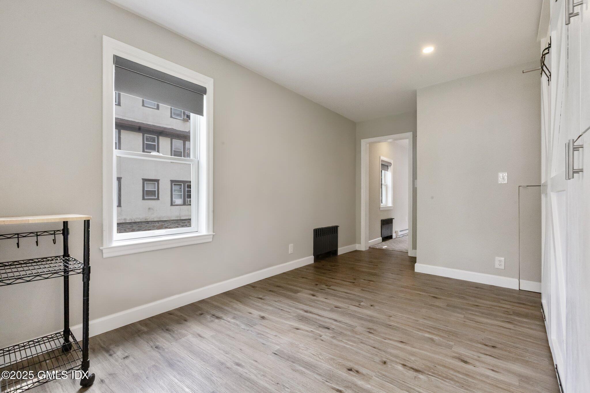 79 Hamilton Avenue, Unit B Greenwich, CT 06830 - Photo 5 of 18 a view of an empty room with wooden floor and a window