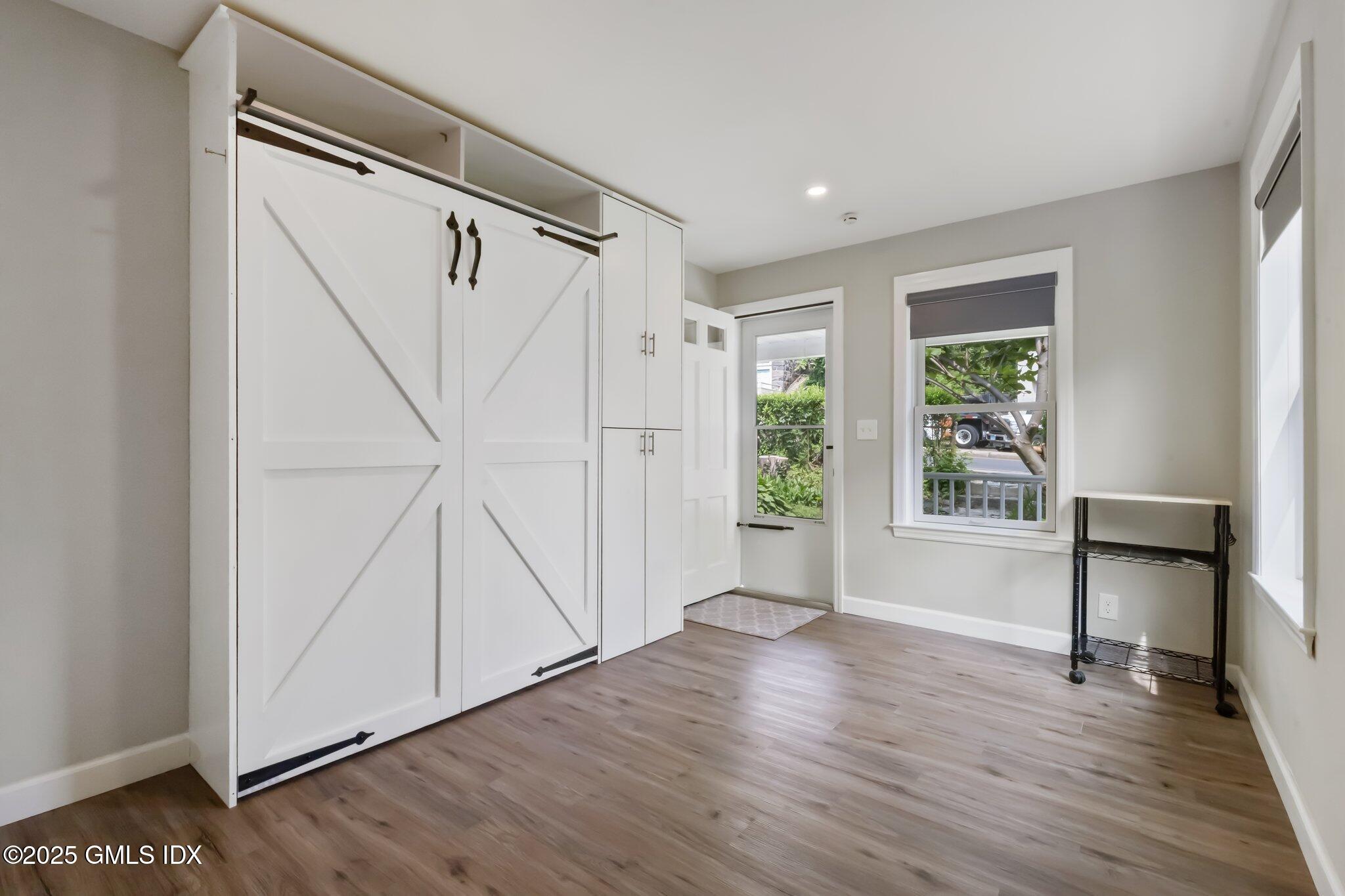 79 Hamilton Avenue, Unit B Greenwich, CT 06830 - Photo 9 of 18 a view of an empty room with wooden floor and a window