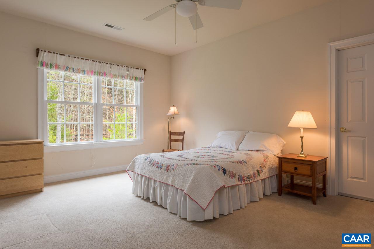 3392 Darby Road Keswick, VA 22947 - Photo 11 of 23 a bedroom with a bed lamp and a chandelier