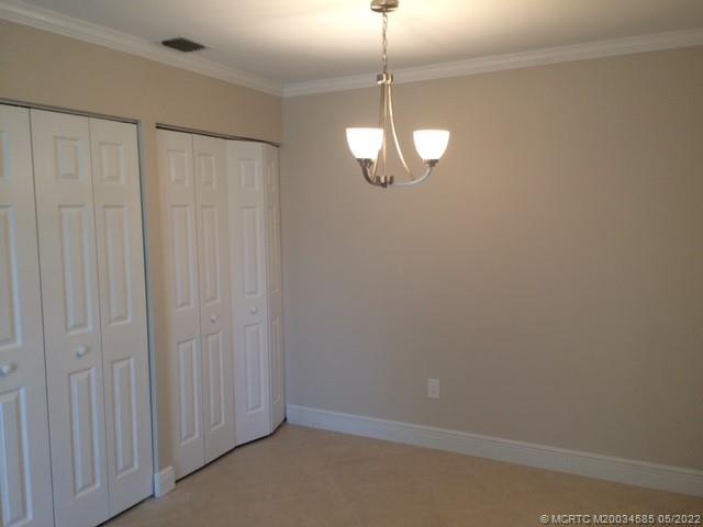 3994 Northwest Cinnamon Tree Circle Jensen Beach, FL 34957 - Photo 12 of 14 a view of a chandelier fan and hardwood floor