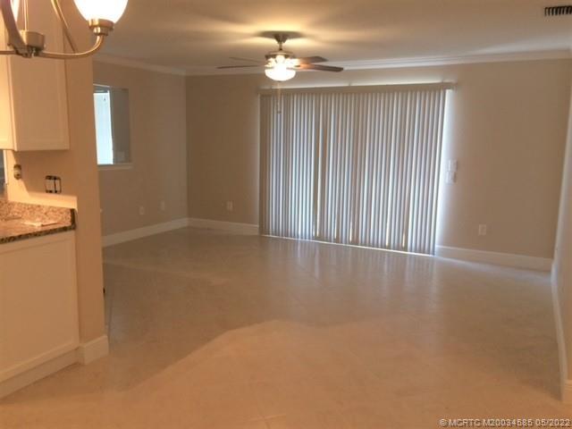 3994 Northwest Cinnamon Tree Circle Jensen Beach, FL 34957 - Photo 4 of 14 a view of a kitchen with wooden floor and a ceiling fan