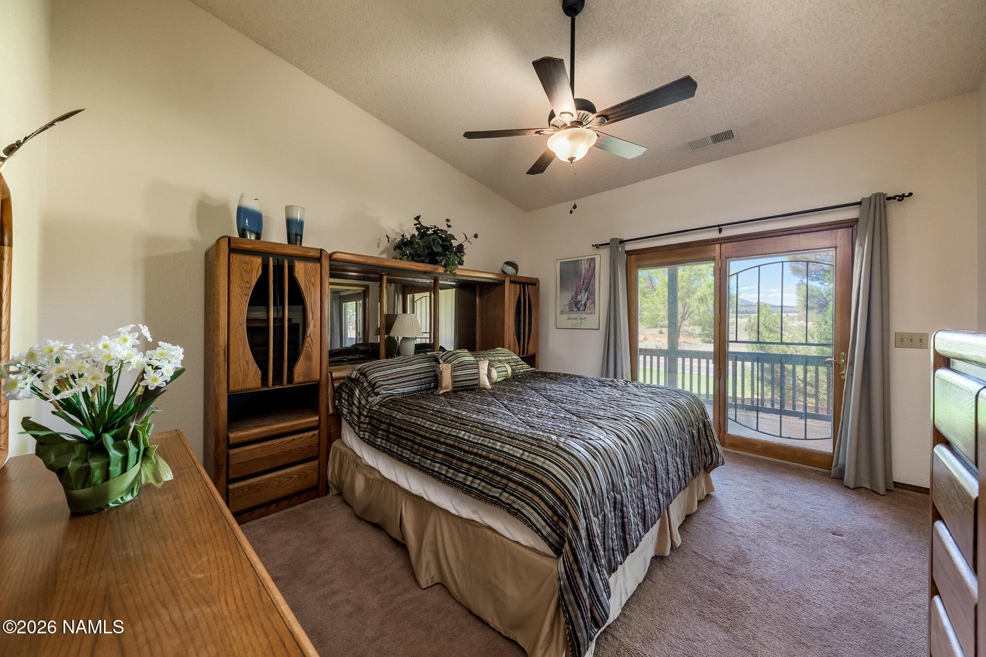 6000 East Laurel Loop, Unit 11 Flagstaff, AZ 86004 - Photo 29 of 54 a spacious bedroom with a bed and a chandelier