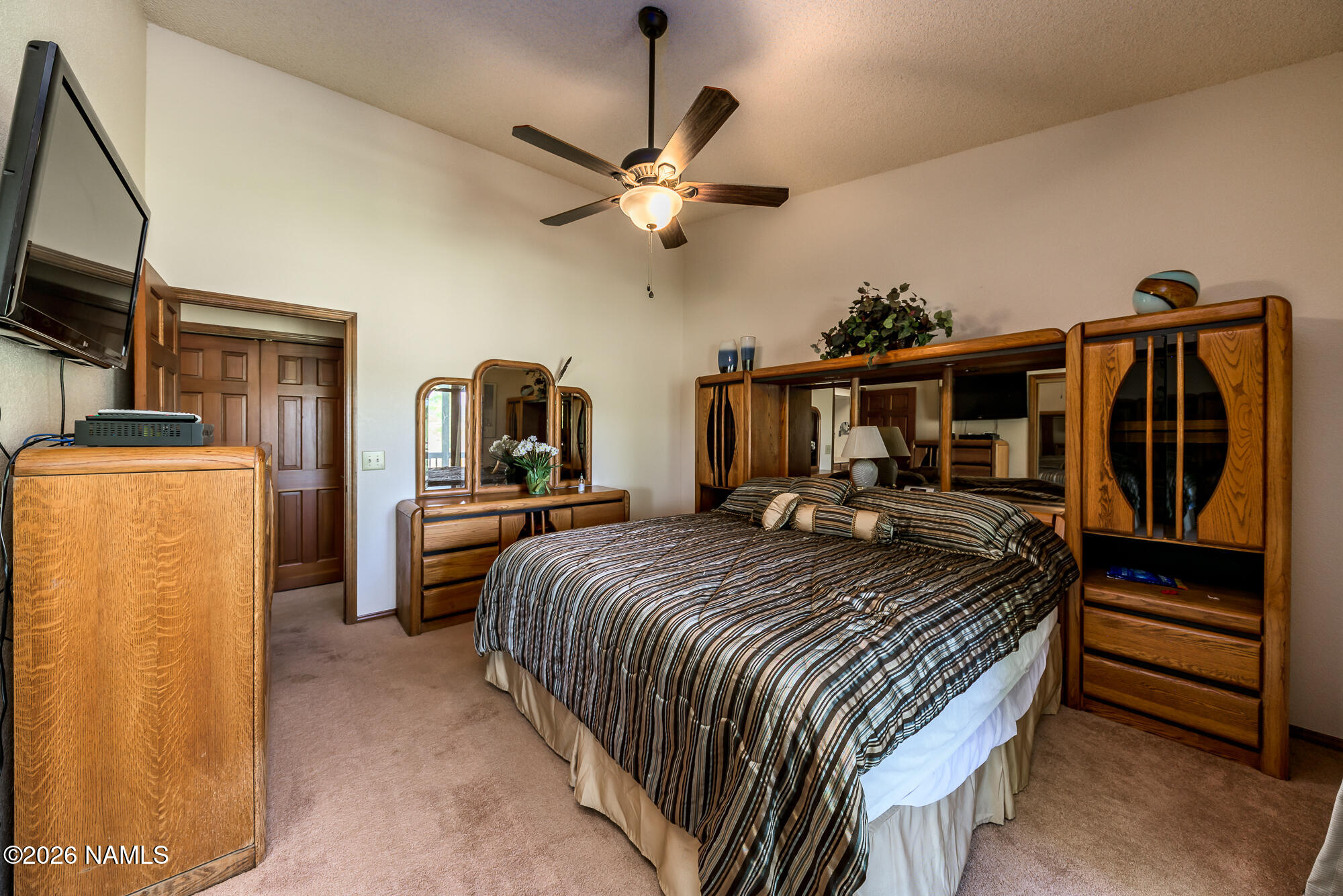 6000 East Laurel Loop, Unit 11 Flagstaff, AZ 86004 - Photo 30 of 54 a bedroom with a bed a dresser and flat screen tv