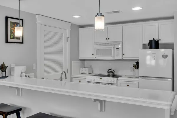 a kitchen with white cabinets and sink
