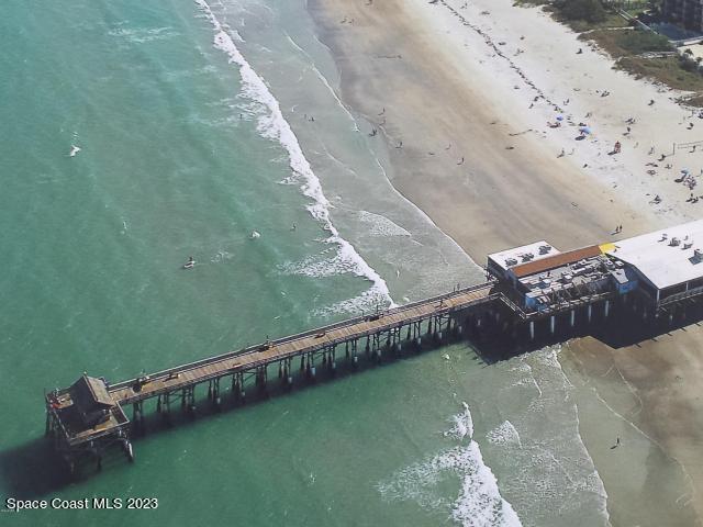 1830 North Atlantic Avenue, Unit 205 Cocoa Beach, FL 32931 - Photo 25 of 28 a wooden bench sitting in the middle of a beach