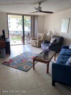 1830 North Atlantic Avenue, Unit 205 Cocoa Beach, FL 32931 - Photo 5 of 28 a living room with furniture and a floor to ceiling window