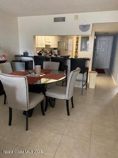 1830 North Atlantic Avenue, Unit 205 Cocoa Beach, FL 32931 - Photo 10 of 28 a dining room with a table chairs and a window