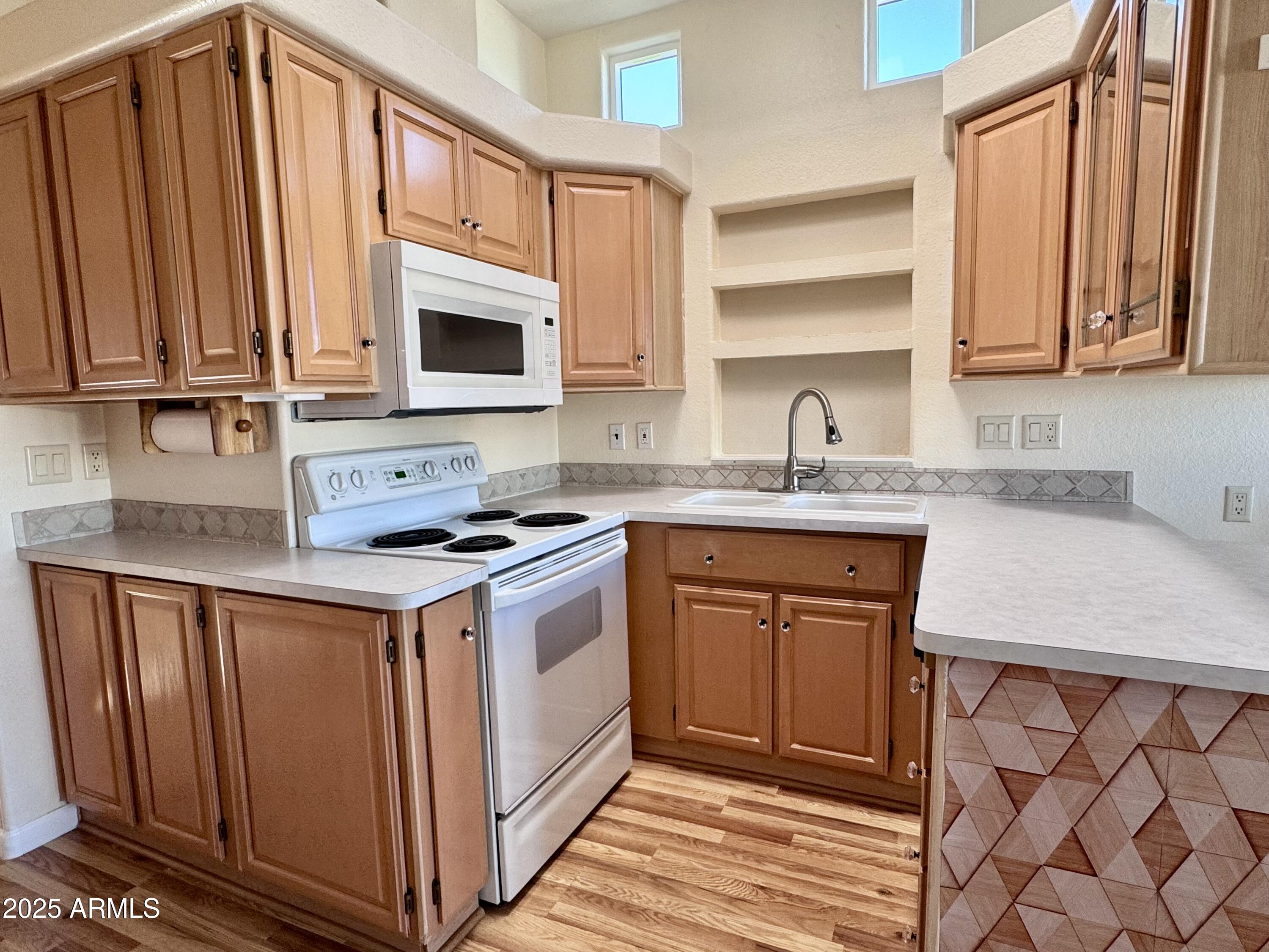 17200 West Bell Road, Unit 454 Surprise, AZ 85374 - Photo 7 of 24 a kitchen with granite countertop a sink stove and cabinets