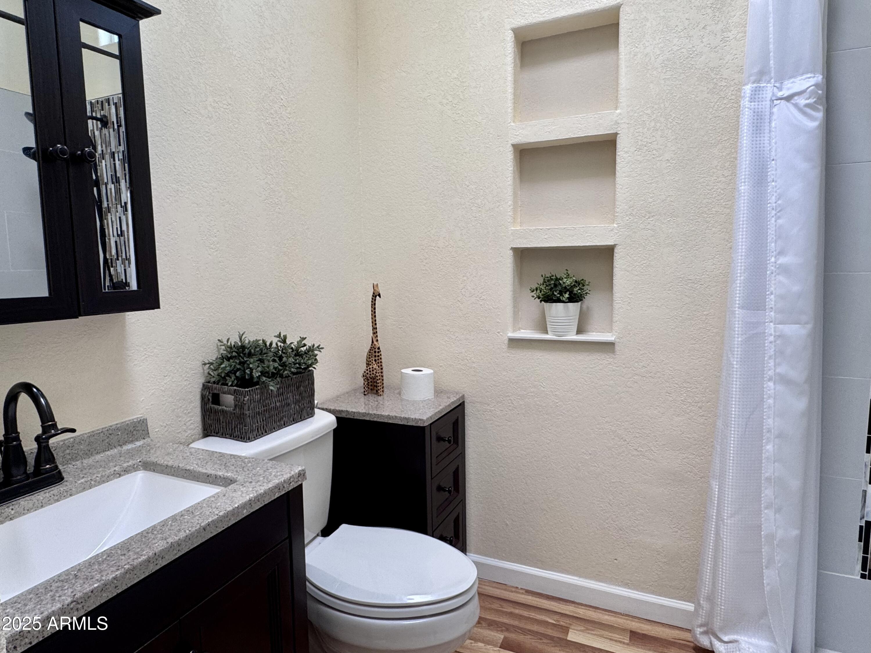 17200 West Bell Road, Unit 454 Surprise, AZ 85374 - Photo 8 of 24 a bathroom with a toilet a sink and mirror