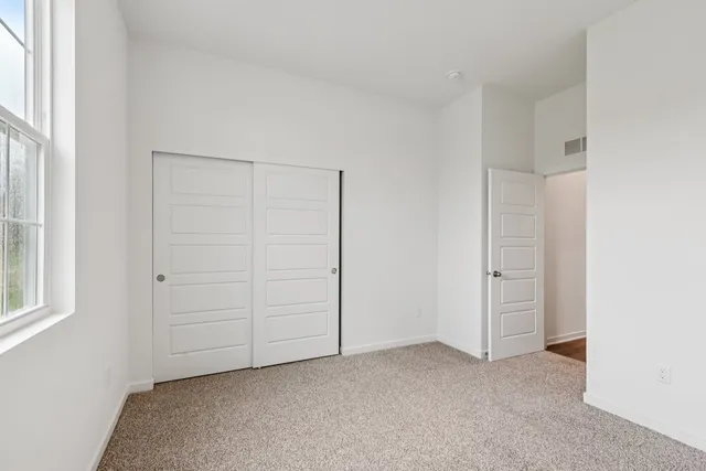 an empty room with windows and closet