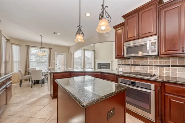 a large white kitchen with a stove and a large window
