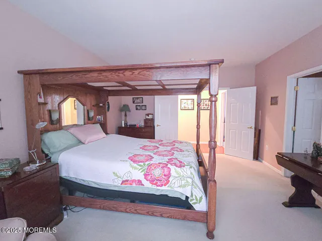 a bedroom with a bed and a mirror on dresser
