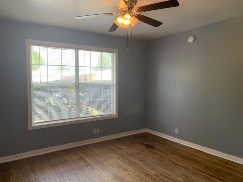 1025 6th Street Hempstead, TX 77445 - Photo 6 of 11 a view of an empty room with wooden floor and a window