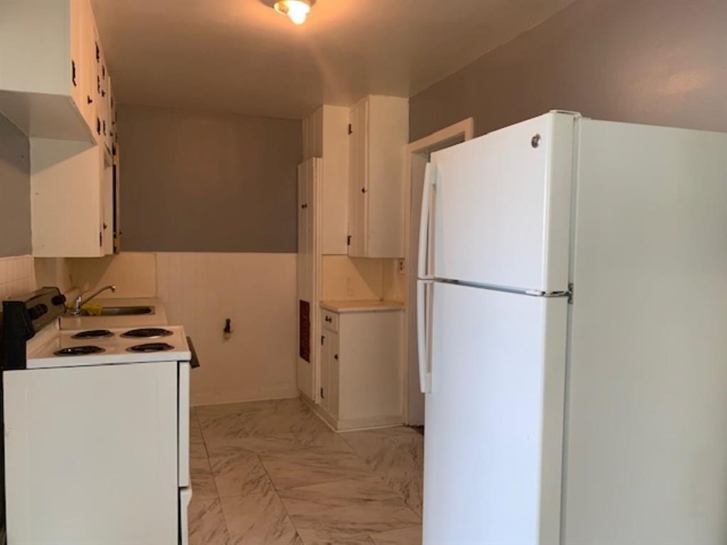 1025 6th Street Hempstead, TX 77445 - Photo 10 of 11 a white refrigerator freezer and a stove sitting inside of a kitchen