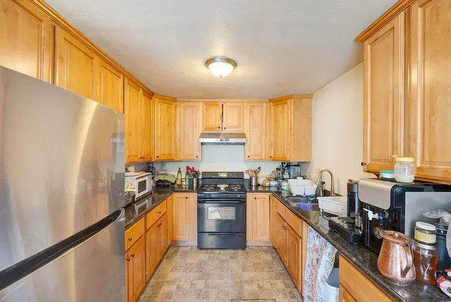 a kitchen with stainless steel appliances a stove sink and cabinets