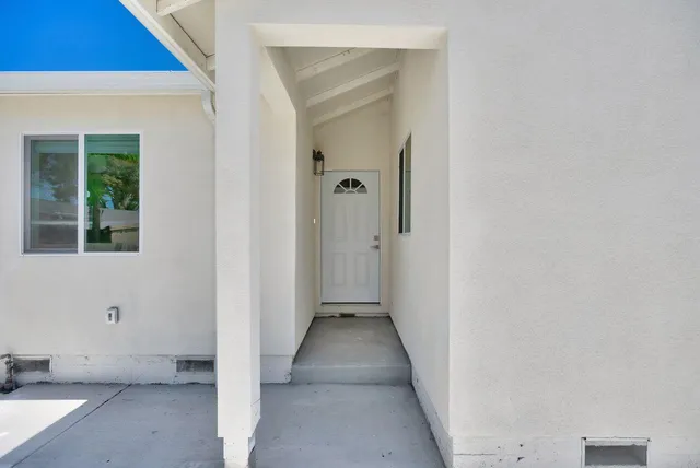 a view of a hallway with wooden floor and a window