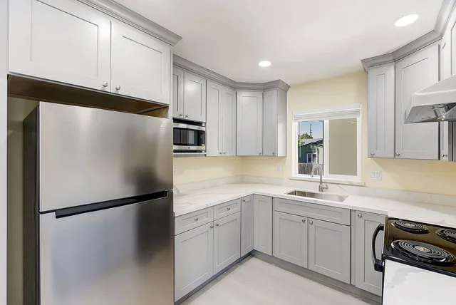 a kitchen with a refrigerator a sink and cabinets