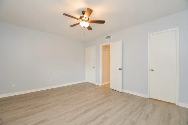 a view of an empty room with wooden floor