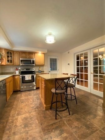 30 Halfrey Road Hubbardston, MA 01452 - Photo 6 of 42 a kitchen with stainless steel appliances granite countertop a stove a sink a microwave dining table and chairs