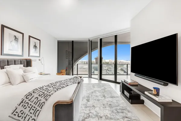 a bedroom with a bed and a flat screen tv