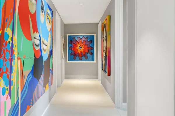 a view of a hallway with painting on the wall