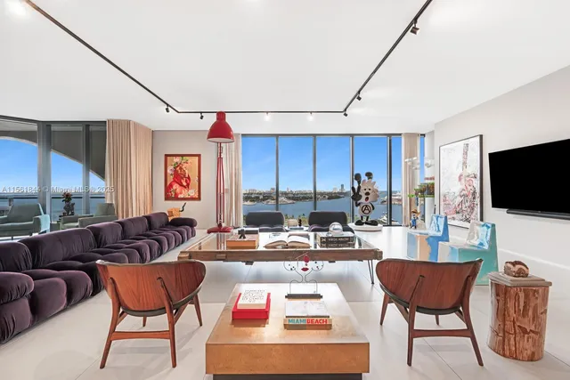 a living room with furniture a flat screen tv and a large window