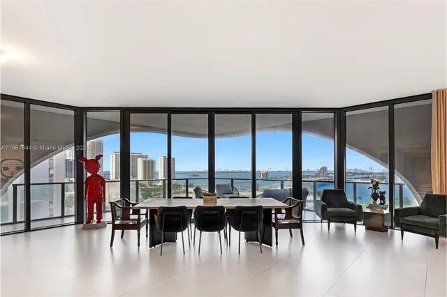 a dining room with furniture water view and large windows
