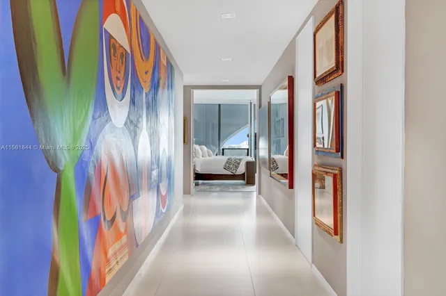 a hallway with painting on the wall and a large window