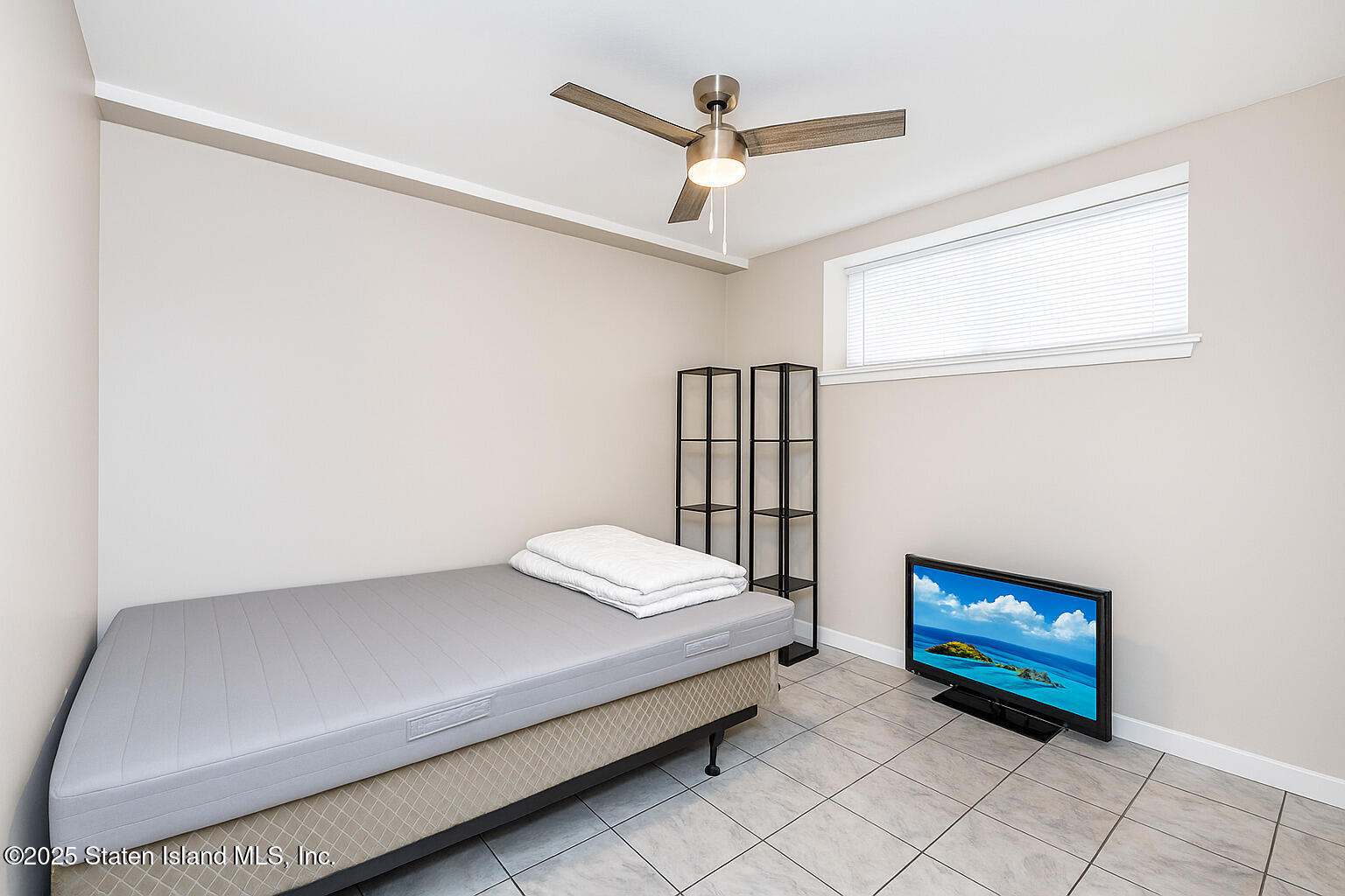 191 Lamberts Lane Staten Island, NY 10314 - Photo 30 of 32 a bedroom with a bed and a book shelf