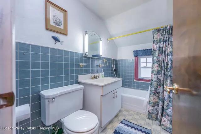a bathroom with a sink toilet vanity and window