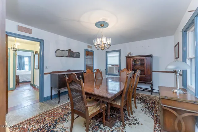 a dining room with furniture a chandelier and wooden floor