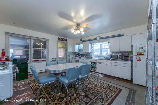 a kitchen with a dining table chairs and refrigerator