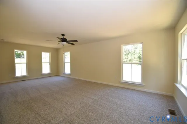 a view of a livingroom with a kitchen stove a sink and a window