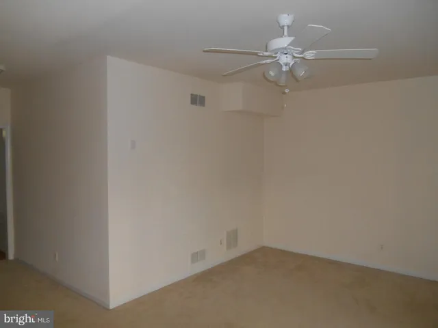 an empty room with a ceiling fan and a window